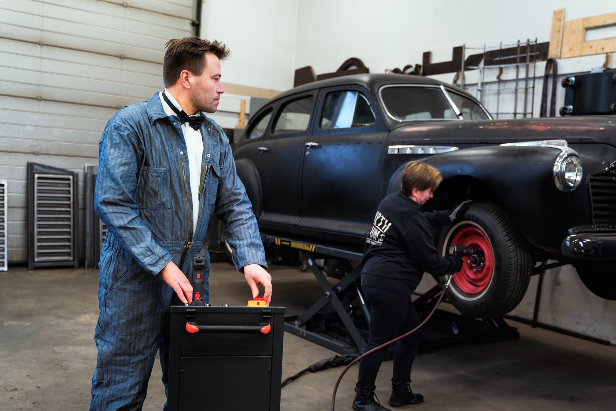 Mies ja nainen vaihtavat autoon rengasta