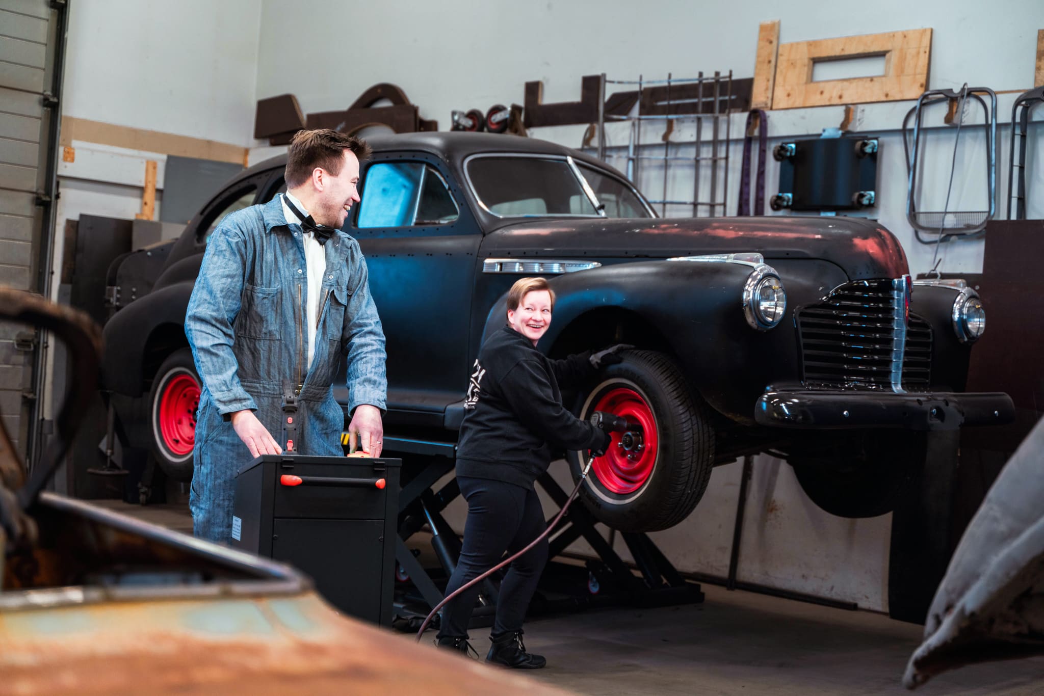 Mies ja nainen vaihtavat autoon rengasta