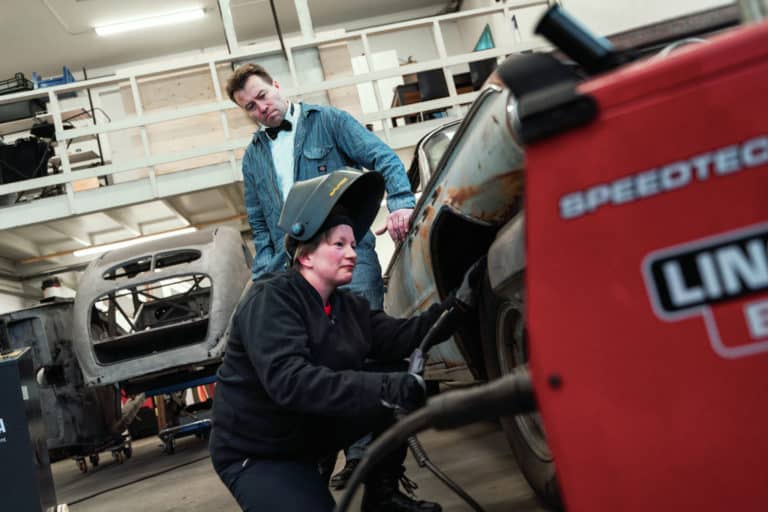 Mies ja nainen vaihtavat autoon rengasta